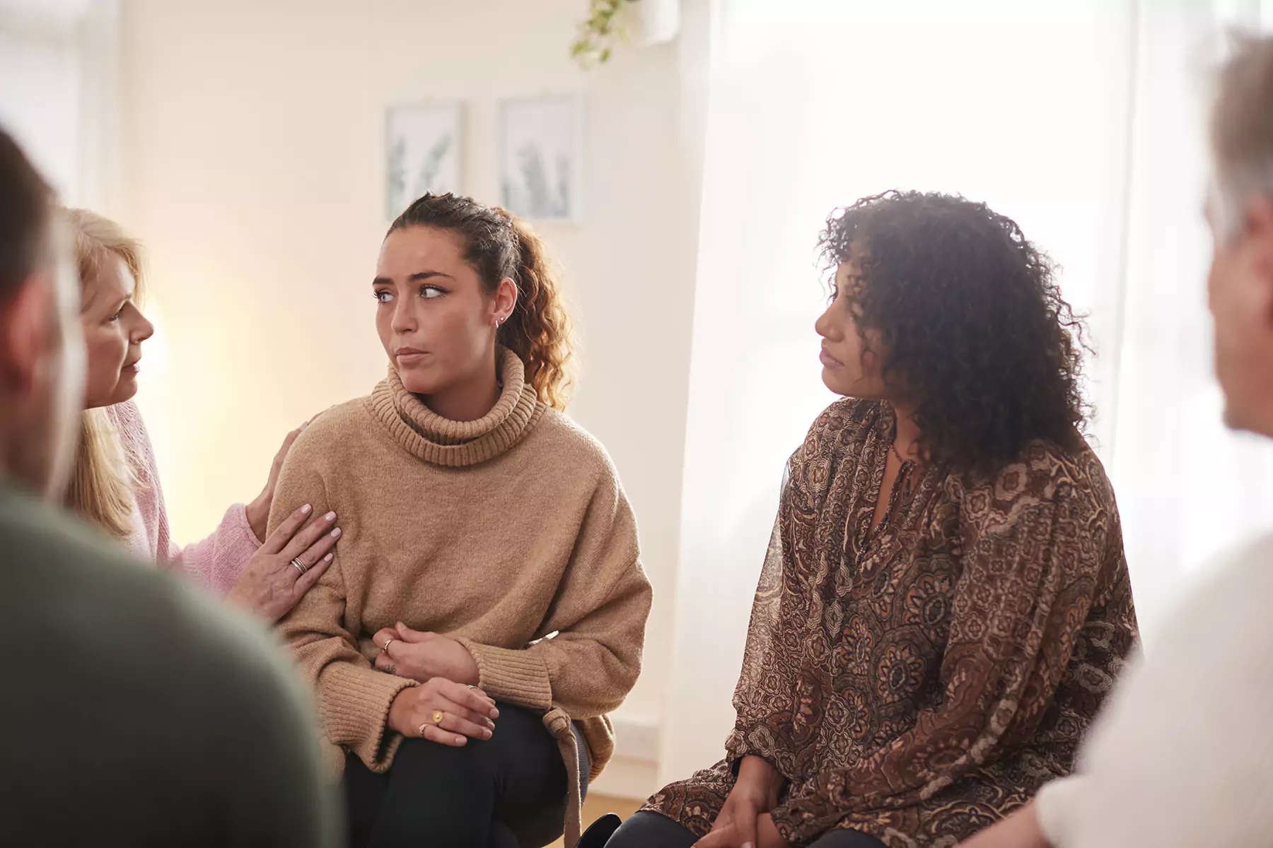 a group of diverse people in a therapy session at the holistic wellness hub